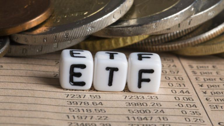 ETF written on dice with coins in the background