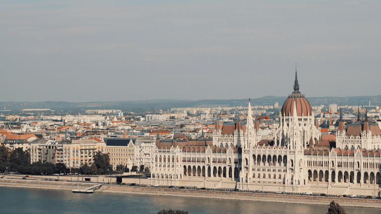 Scenic view of the iconic Hungarian Parliament Building along the Danube River in Budapest.